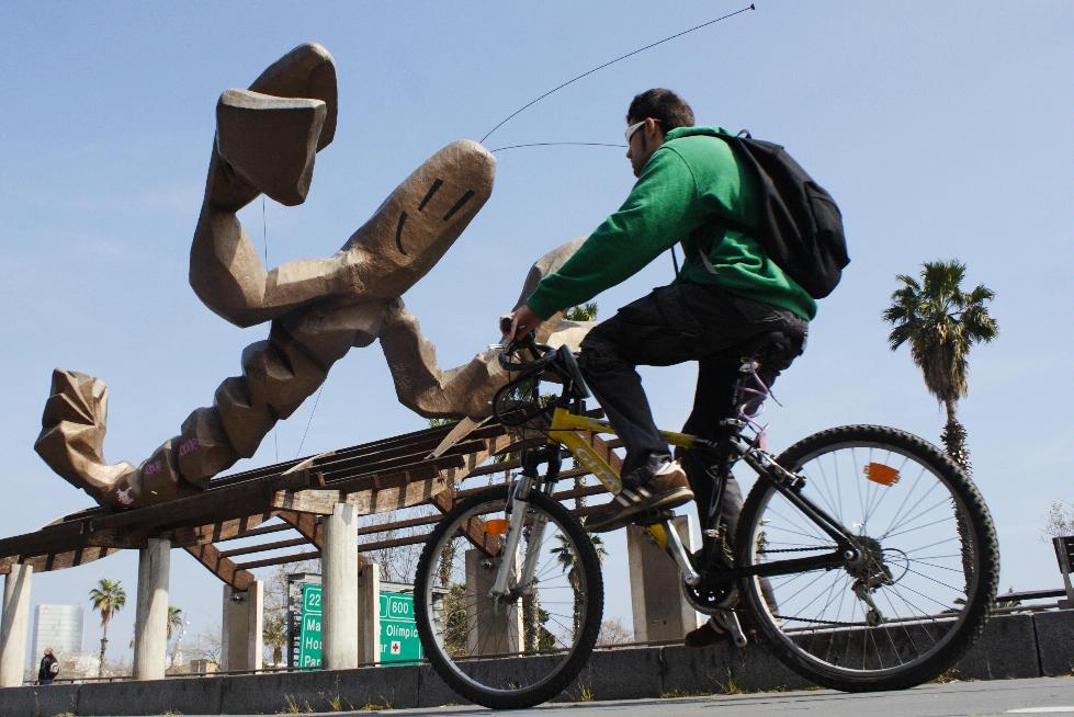 A cyclist passes Xavier Mariscal's Crayfish sculpture on the Moll de la Fusta, Barcelona, Spain