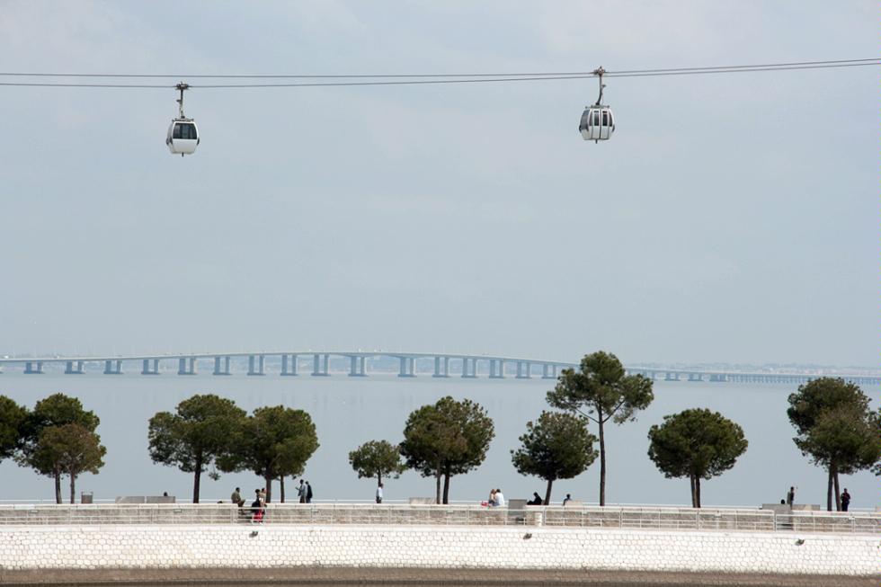 Cable cars aboveParque das Na&ccedil;&otilde;es with Vasco da Gama Bridge beyond, Lisbon, Portugal.