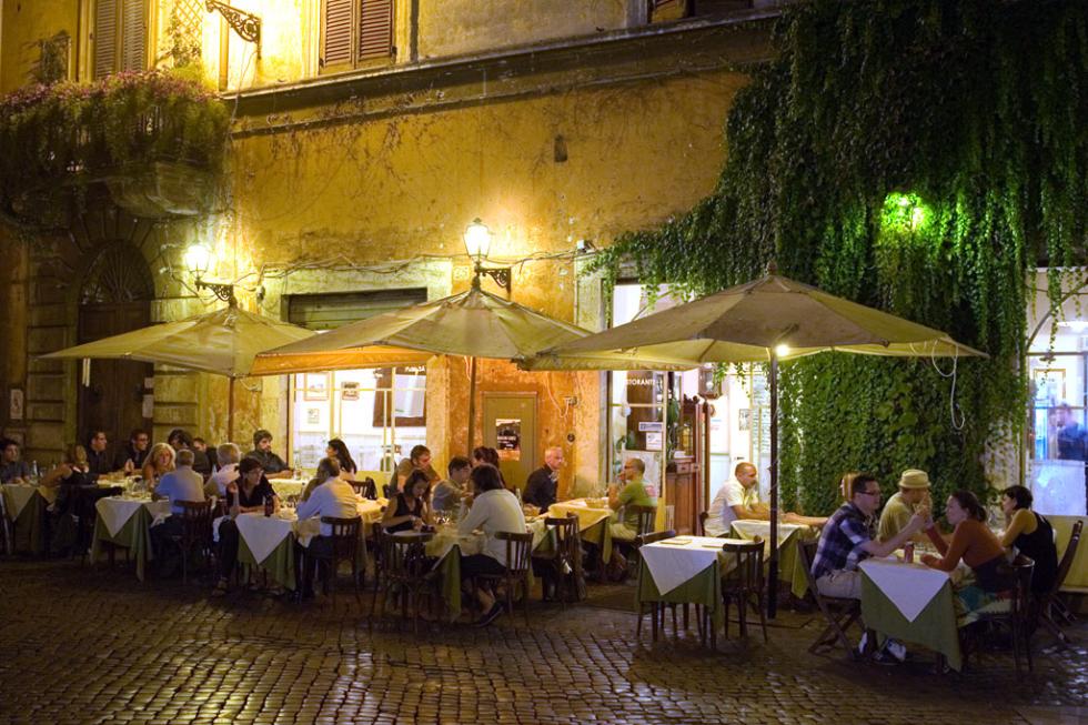 Romans enjoying al fresco dining under umbrellas. Rome, Italy.