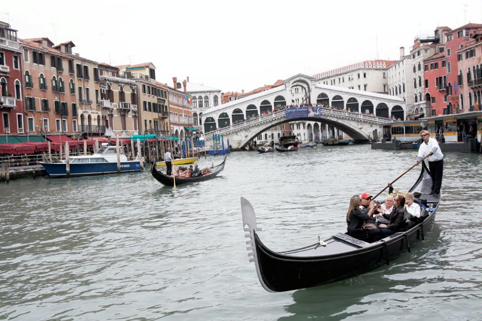 Gondolas along the Grand Canal and Rialto Bridge in background, Venice.