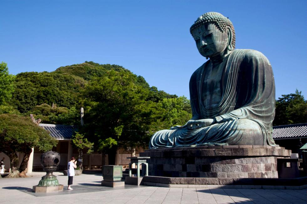 Praying before Daibutsu (Big Buddha) statue at Kotokuin Temple in Kamakura, Japan.