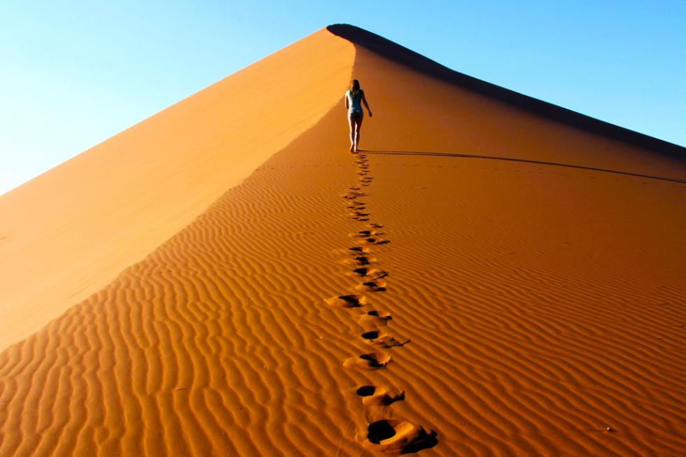 Climbing one of the tallest dunes at sunrise in the Namib-Naukluft National Park in Namibia.